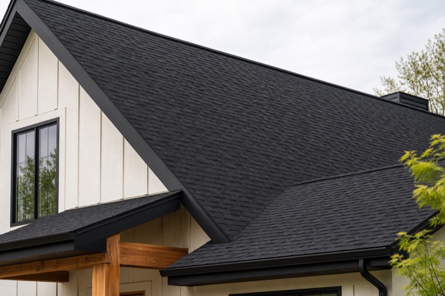 A close view of a dark architectural asphalt shingle roof against a white gable.